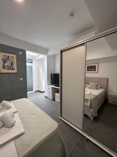 巴尔Hotel MonteNino的一间带镜子、一张床和电视的卧室