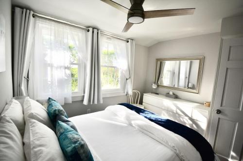 南安普敦Private Summer Rental Beach House with a 30ft Boat Dock的一间卧室设有一张床和两个窗户。
