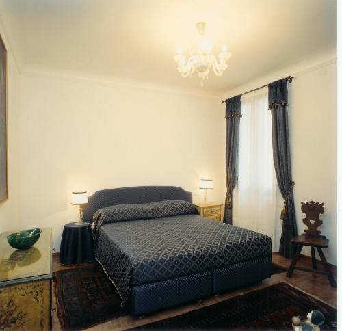 威尼斯卡安杰利酒店的一间卧室配有一张床和一个吊灯