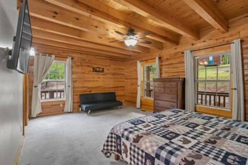 尤里卡斯普林斯Main Lodge at Lake Forest Cabins的小木屋卧室配有床和沙发