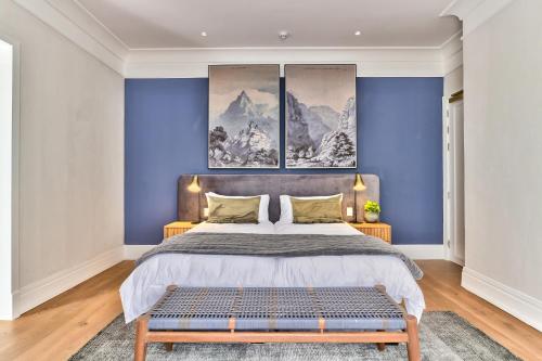开普敦Wytham Manor House的一间卧室配有一张带蓝色墙壁的大床