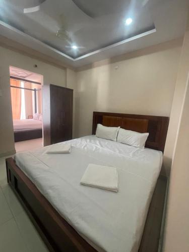 海得拉巴Reef Terrace Unit的一间卧室配有一张带白色床单的大床