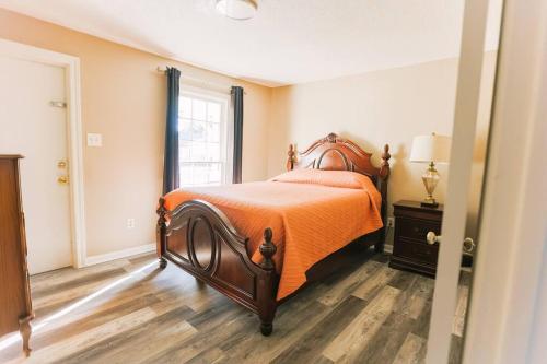 莫比尔Cozy Downtown Gem Fully Equipped Free Parking的一间卧室配有一张带橙色棉被的床和窗户