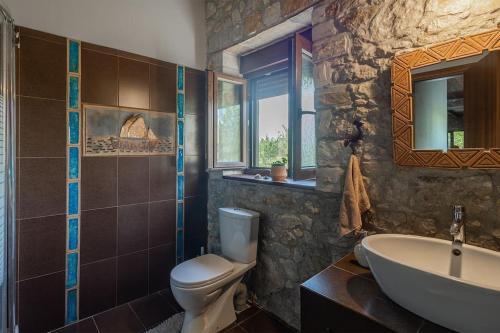 Πέτρινη εξοχική κατοικία, Λάρισα的石质浴室设有卫生间和水槽