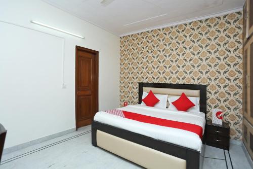 古尔冈OYO Hotel Awesome Villa Near Appu Ghar的一间卧室配有红色枕头的床