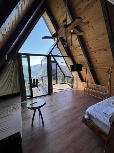 贾马里海姆森Nirvana dağ evleri的一间卧室配有一张床、一张桌子和一个大窗户