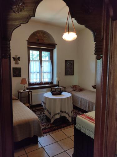 桑加拉达White stone house with great sea view的客房设有两张床、一张桌子和一架钢琴。