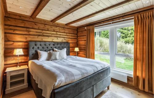 HurdalAwesome Home In Hurdal With Wifi And 5 Bedrooms的小木屋内一间卧室,配有一张床