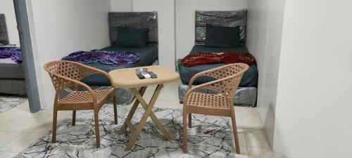 开罗Best Dreams Hotel的一张桌子和两把椅子,位于一个配有床的房间