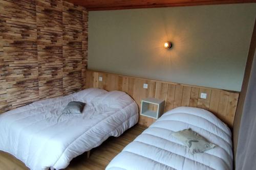 旺特龙Maison de montagne vue magnifique的一间卧室设有两张床和砖墙