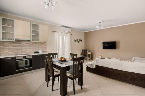 卡拉瓦杜斯Mandi's Apartments的厨房以及带桌椅的起居室。