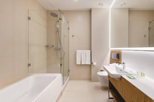 华沙华沙机场万怡酒店的带浴缸、盥洗盆和卫生间的浴室