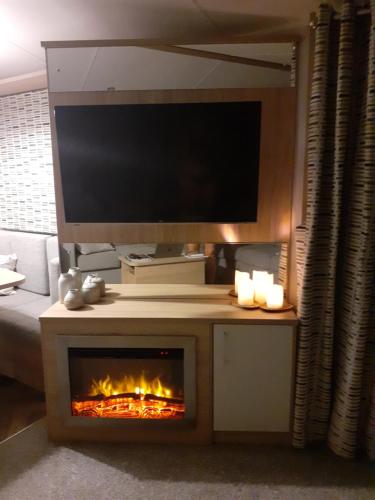 梅布尔索普Golden Sands Retreat的一间带电视和壁炉的客厅
