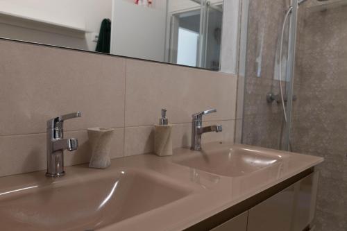 代森扎诺-德尔加达Estate的浴室水槽设有2个水龙头和镜子