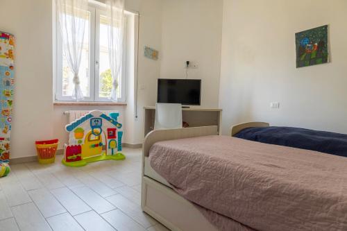 代森扎诺-德尔加达Estate的一间卧室设有一张床和一个玩具屋