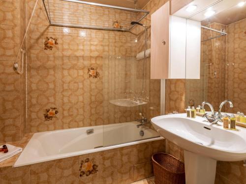 拉克吕萨Appartement La Clusaz, 3 pièces, 8 personnes - FR-1-437-36的浴室配有盥洗盆、浴缸和盥洗盆