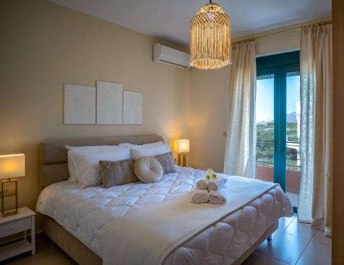 考瑙皮迪亚纳Helen Sweet Home的卧室配有一张带吊灯的大型白色床。