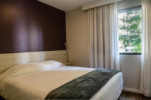 圣保罗大道花园旅游酒店的一间卧室设有一张床和一个窗口
