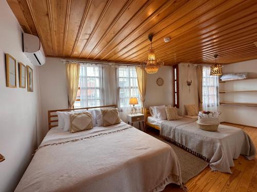 艾瓦勒克Hanole Guest House的一间卧室设有两张床和木制天花板