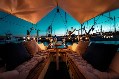 卡列罗港Seaside Chill-out Stay on a Sail Yacht的船上的沙发和甲板上的桌子