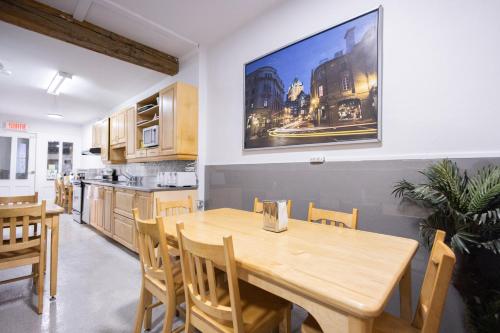 魁北克市Auberge de la paix的厨房以及带木桌和椅子的用餐室。