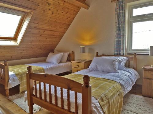 Aughrus MoreLands End Cottage - Connemara的带2扇窗户的客房内的2张床