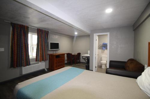 圣贝纳迪诺Starlite Motel的一间卧室配有一张床、一张书桌和一台电视