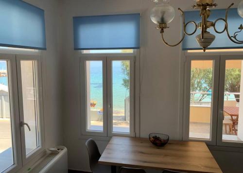 弗隆塔多斯Blue Flag Award Winning Beach: Home 2的一间带木桌和窗户的用餐室