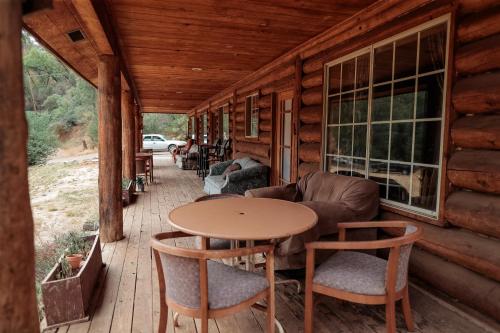 米德派恩斯熊溪小屋酒店的小木屋的门廊配有桌椅