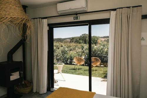 Casais BrancosCasa da Aldeia - Small House -Terra - Peniche - Baleal的卧室设有滑动玻璃门,可通往庭院。