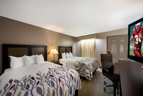 杰斯帕Red Roof Inn Jasper的酒店客房设有两张床和一台平面电视。