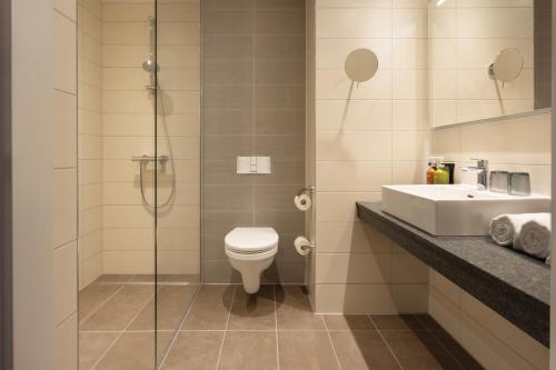 埃因霍温Holiday Inn - Eindhoven Airport, an IHG Hotel的浴室配有卫生间、盥洗盆和淋浴。