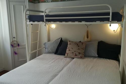 尼格兰Acogedor apartamento a pie de playa的一间卧室配有带白色床单和枕头的双层床