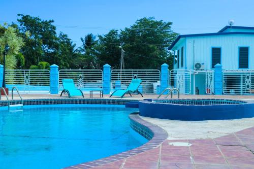 卡沃罗霍MAVS COMBATE BEACH CLUB的一座房子旁的游泳池,配有蓝色的椅子