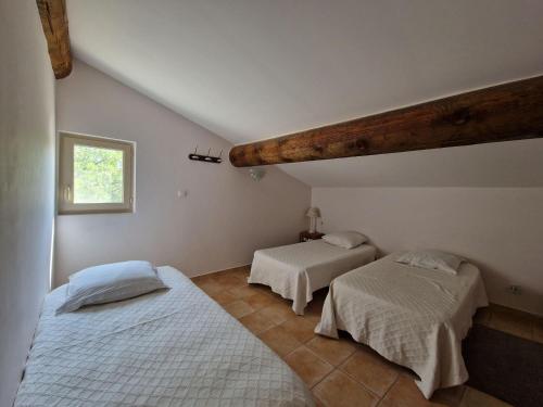 拉科斯特Semi-detached house, Lacoste的一间卧室设有两张床和窗户。