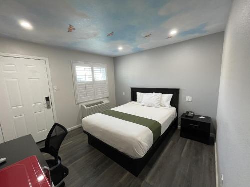 方塔纳Fontana Inn的卧室配有床、书桌和门