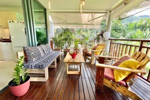 普纳奥亚Vaiava Beach Carlton- Tahiti - beachfront luxury residence & pool - 4 pers的甲板上配有长椅和桌子的门廊