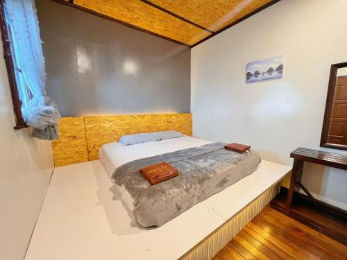 仙本那Singamata Resort的卧室位于客房的角落,配有一张床