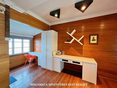 仙本那Singamata Resort的配有书桌和红色椅子的房间