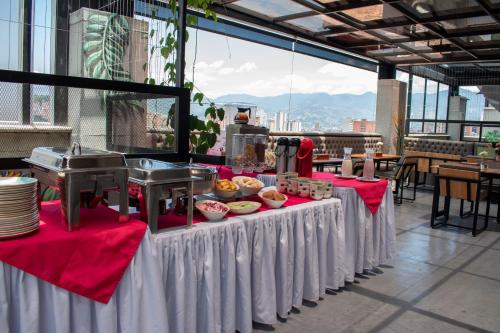 麦德林Edificio Helena的一张桌子,上面有食物,上面有红白桌布