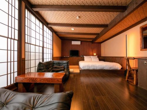 MiyajiTsuruya / Vacation STAY 59065的酒店客房配有床、沙发和桌子。
