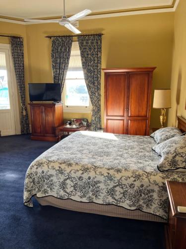 约克The York Palace Accommodation的一间卧室配有一张床和一台平面电视
