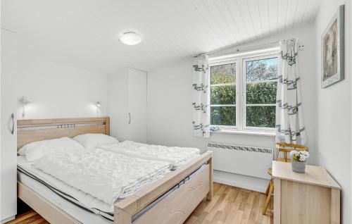 StavrebyBeautiful Home In Prst With House Sea View的白色的卧室设有一张大床和一个窗户