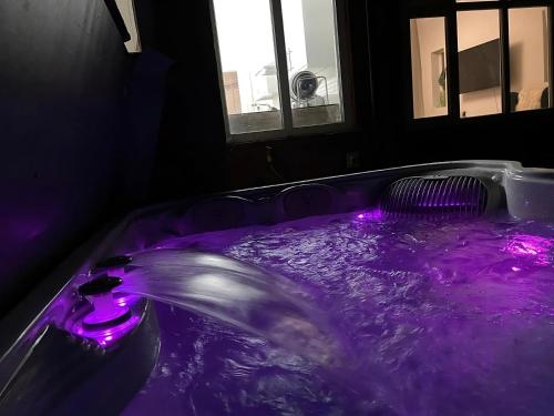 曼彻斯特The Safari House - Your Ultimate Relaxation Destination的紫色浴缸,紫色灯在房间内