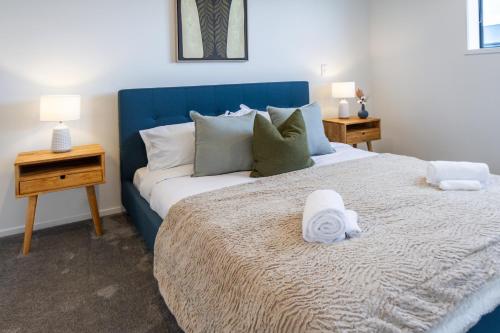 基督城The Tranquil Terrace - Zen zone 2 bed 2 bath的一间卧室配有一张大床和蓝色床头板