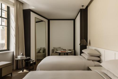悉尼Capella Sydney的酒店客房,配有两张床和椅子