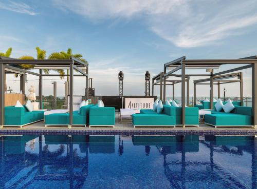 新加坡The Outpost Hotel Sentosa by Far East Hospitality的水边的游泳池配有蓝色躺椅