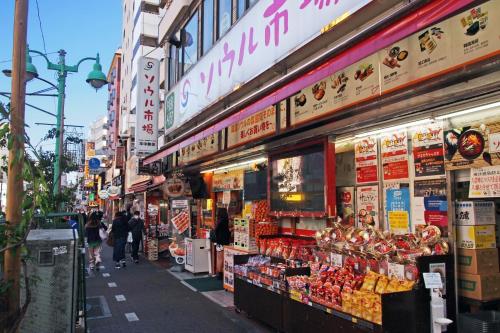 东京Hotel RIO新宿的大街上的人在商店前走