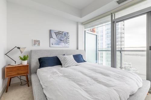 多伦多多伦多市中心云9公寓的一间卧室设有一张大床和一个大窗户