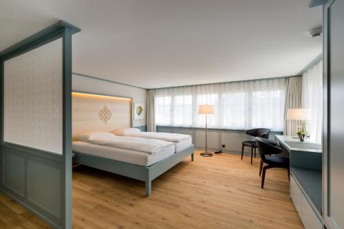 斯派克Hotel Krone Speicher的酒店客房配有一张床、一张书桌和一张书桌。